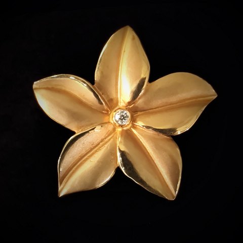 Bræmer-Jensen; A flower brooch of 14k gold with a diamond