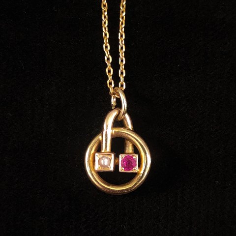A necklace set with a ruby and a pearl, mounted in 14k gold