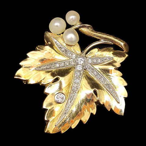 A brooch in 14k gold and white gold set with pearls and diamonds